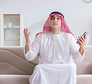 Arab man watching sport football at tv