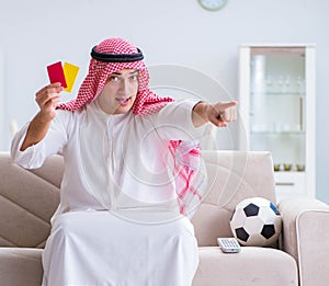 Arab man watching sport football at tv