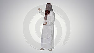 Arab man wearing keffiyeh making wellcome gesture on gradient ba photo