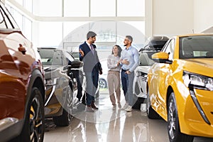 Arab man and woman choosing car at auto dealership