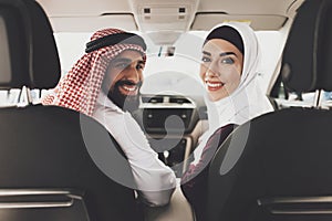 Arab man with a woman turned around in a new car.