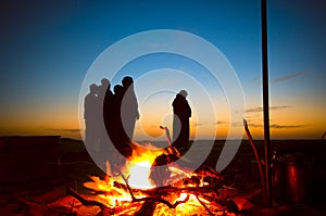 Arab men praying Ishaa in the desrt beside a fire place