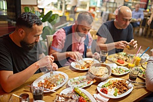 Arab men in restaurant enjoying Middle Eastern food