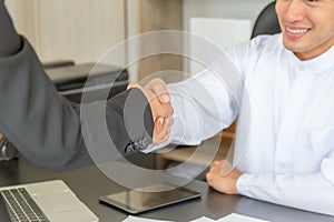 Arab middle eastern businessman and business woman make handshakes, finishing up meeting