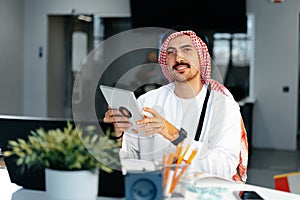 Arab muslim businessman using digital tablet in modern office