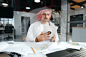 Arab muslim businessman using digital tablet in modern office