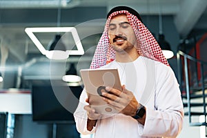 Arab muslim businessman using digital tablet in modern office