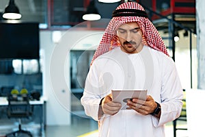 Arab muslim businessman using digital tablet in modern office