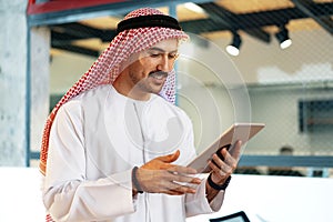 Arab muslim businessman using digital tablet in modern office