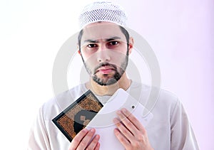 Arab muslim man with koran holy book and pc tablet