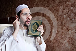 Arab muslim man with Koran islamic holy book and headset