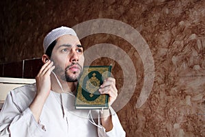 Arab muslim man with Koran islamic holy book and headset