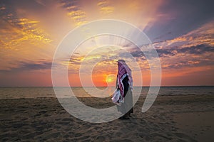 An arab old man standing in Fanateer beach with sunrise background. Al Jubail City -Saudi Arabia photo