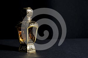 Arab perfume in a bottle, isolated in black background, in low l