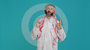 Arab person poses with fingers crossed