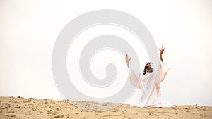 Arab raising hands to heaven, praying on knees, asking Allah to forgive sins