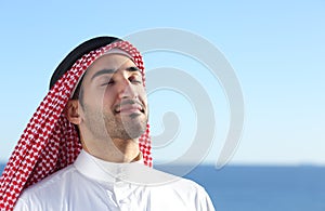 Arab saudi man breathing deep fresh air in the beach