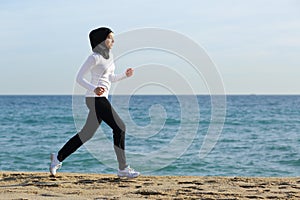 Arab saudi runner woman running on the beach photo