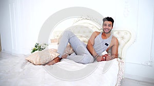 Arab Shooting Man Portrait Smiling And in Good Mood on Bed in Bright Bedroom.