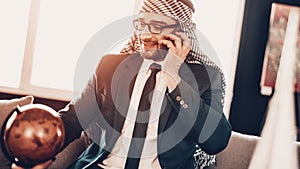 Arab talking on phone and looking at globe