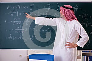 The arab teacher in front of chalkboard