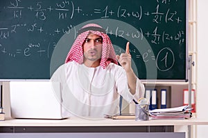The arab teacher in front of chalkboard
