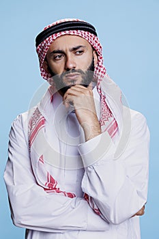 Arab in traditional attire contemplating