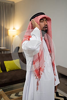 an Arab in a turban praying during the takbir movement