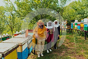 Arab woman investitors with an experienced senior beekeeper checking the quality and production of honey at a large bee