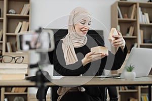 Arab woman using smart phone camera for creating content.