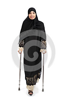 Arab woman walking with crutches photo