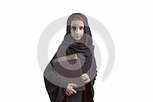 Arabic student wearing abaya, holding book..Arab young girl dressed in black abaya with books in her hands, girl student photo