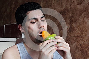 Arab young man eating mango fruit