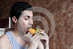 Arab young man eating mango fruit