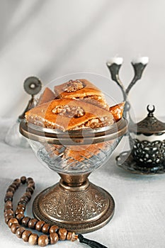 Arabian Baklava with nuts and honey on white background, top view. Ramadan dessert - fresh assorted nut baklava.