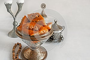 Arabian Baklava with nuts and honey on white background, top view. Ramadan dessert - fresh assorted nut baklava.