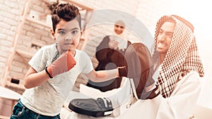 Arabian Boy Boxing with Young Father at Home.