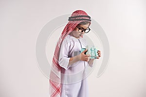 Arabian boy in keffiyeh opens present.