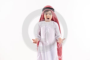 Arabian boy in keffiyeh stands in amazement.