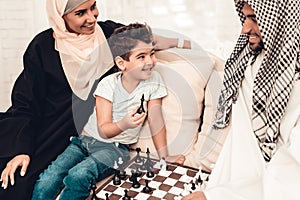 Arabian Boy Playing Chess with Father at Home