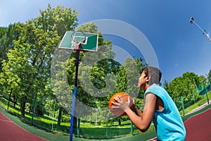 Arabian boy ready to throw ball in basketball goal