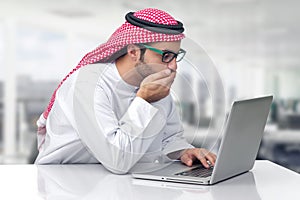 Arabian business man looking shocked at his computer