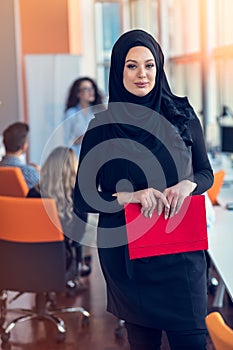 Arabian business woman holding a folder in modern startup office