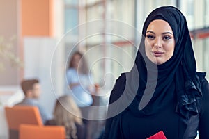 Arabian business woman holding a folder in modern startup office