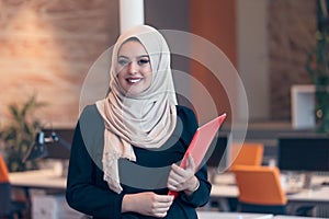 Arabian business woman holding a folder in modern startup office