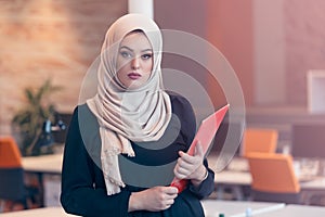 Arabian business woman holding a folder in modern startup office