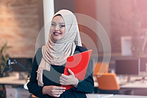 Arabian business woman holding a folder in modern startup office