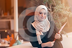 Arabian business woman holding a folder in modern startup office