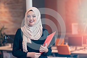 Arabian business woman holding a folder in modern startup office