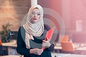 Arabian business woman holding a folder in modern startup office